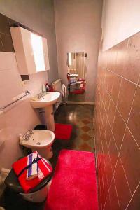 y baño con lavabo, aseo y alfombra roja. en Il Tiglio, en Monsagrati