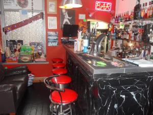 um bar com paredes vermelhas e bancos vermelhos em Bradleys Hotel em Blackpool