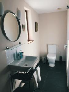 a bathroom with a sink and a mirror and a toilet at Flores Amarillas B&B in Almoharín