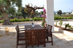 a wooden table and chairs with a potted plant on it at case per vacanze torre incina in Polignano a Mare