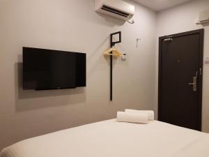a bedroom with a bed with a flat screen tv on the wall at The Leverage Lite (Kuantan) in Kuantan