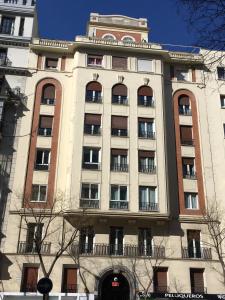 - un grand bâtiment avec des fenêtres sur le côté dans l'établissement Hostal Retiro, à Madrid