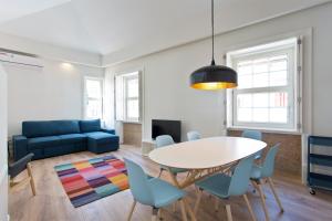 ein Wohnzimmer mit einem Tisch, Stühlen und einem Sofa in der Unterkunft RVA - Clerigos Apartments in Porto