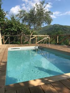 een groot zwembad met een houten terras bij piscina con vista in Bagni di Lucca