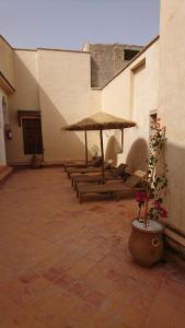 een rij banken met parasols op een binnenplaats bij Riad jasmins & Spa in Fès