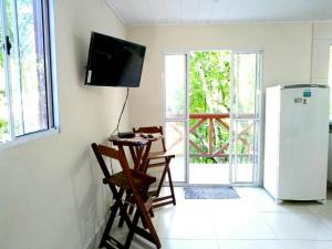 Cette chambre dispose d'un réfrigérateur et d'une télévision murale. dans l'établissement Casa da Floresta, à Parati