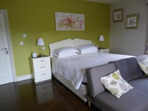 a bedroom with a large bed and a couch at Arvalee Retreat With Outdoor HotTub in Omagh