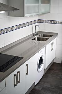 a white kitchen with a sink and a dishwasher at Apartamento Plaza del Socorro in Ronda