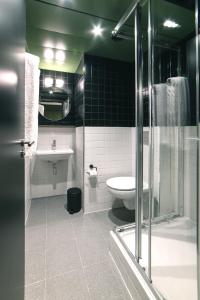 a bathroom with a toilet, sink, and shower stall at Generator Madrid in Madrid