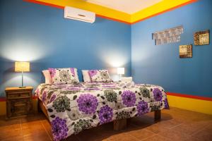 een slaapkamer met een bed met paarse en blauwe muren bij Casa Juarez B&B in La Paz