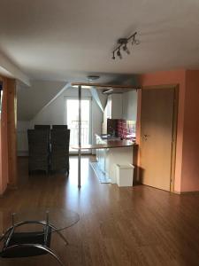 an empty living room with a table and a kitchen at Penzión Kotva Prístav in Námestovo