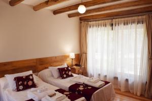 una camera d'albergo con due letti e una finestra di Las Dalias a Villa Las Rosas