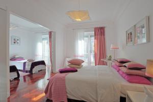 リスボンにあるLiverpool Antic 5 Bedroomsの白いベッドルーム(ピンクの枕が付いた大型ベッド付)