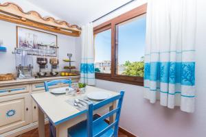 a kitchen with a table and chairs and a window at Faunele in Orosei