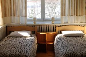 two beds in a room with a window at Helge Guest House in Valga