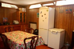 a kitchen with a table and a white refrigerator at Villa Andrea in Bari
