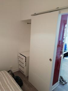 ein Schlafzimmer mit einem Bett, einer Kommode und einem Schrank in der Unterkunft appartement de la place in Dieppe