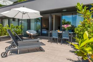a patio with an umbrella and chairs and a table at FeelFree STAYS Basoa in Donostia-San Sebastián