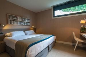 a bedroom with a bed and a desk and a window at FeelFree STAYS Basoa in Donostia-San Sebastián