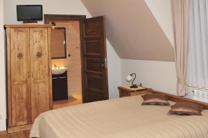 a bedroom with a bed and a bathroom with a sink at Willa Wiktoria in Bukowina Tatrzańska