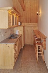 a kitchen with wooden cabinets and a sink and a counter at Willa Wiktoria in Bukowina Tatrzańska
