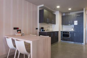 a kitchen with a wooden table and white chairs at FeelFree STAYS Basoa in Donostia-San Sebastián