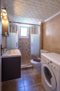 een badkamer met een wasmachine en een wastafel bij Artemis - Athens Deluxe City Center Apartment in Athene