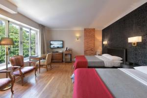 a hotel room with two beds and a desk at Hotel Bonaparte in Montreal