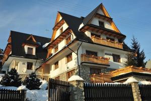 a large white house with a black roof at Willa Wiktoria in Bukowina Tatrzańska
