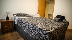 una camera da letto con un letto con un piumone bianco e nero di Apartments Madrid Eliptica a Madrid