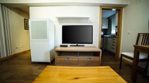 - un salon avec une télévision sur une commode en bois dans l'établissement Apartments Madrid Eliptica, à Madrid