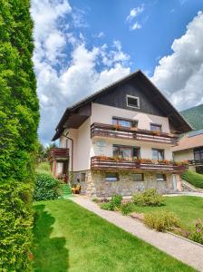 una casa con un perro sentado frente a ella en Apartments and Rooms Banić en Kranjska Gora