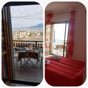 een kamer met een rood bed en een tafel met uitzicht bij B&B La Panoramica in Casola di Napoli
