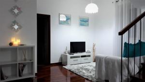 a white room with a bed and a television at Casa da Avó Irene in Funchal