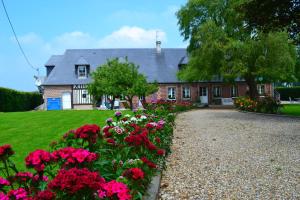 Saint-Maclou-de-Folleville的住宿－La Cle de Saule，一座房子前面有鲜花的花园