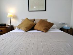 een slaapkamer met een bed met 2 kussens erop bij Suitur Atico Sitges Centro in Sitges