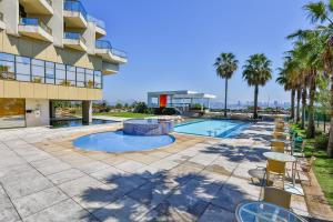 uma vista para um edifício com piscina e palmeiras em Hotel Orizzonte Niteroi by Atlantica em Niterói