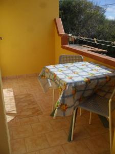 ランペドゥーザにあるCasa Vacanze Cala Pisanaのテーブルと椅子、バルコニー(キルト付)