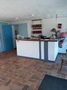 a kitchen with blue walls and a counter in a room at Hotel Les Esseppes in LʼÉpine