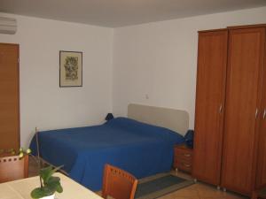 a bedroom with a blue bed and a wooden cabinet at Apartments Spert in Umag