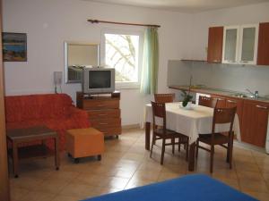 a living room with a couch and a table with a television at Apartments Spert in Umag