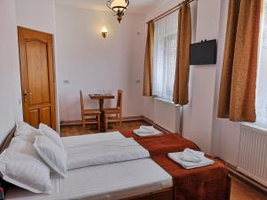 1 dormitorio con 2 camas y mesa. en Pensiunea Casa Sighisoreana, en Sighişoara
