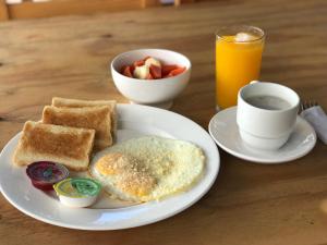 ein Frühstücksteller mit Eiern, Toast und einer Tasse Kaffee in der Unterkunft Techos Azules in Taganga