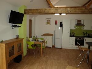 a kitchen with a table and chairs in a room at The Courtyard at Lodge Farm in Norwich