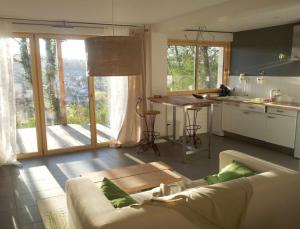 a living room with a couch and a kitchen with a table at Home 33 in Saint-Rémy-lès-Chevreuse