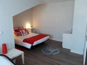 アヴェイロにあるCasa Pirosa2の小さなベッドルーム(赤い枕のベッド付)