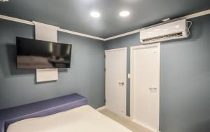 a room with a bed and a flat screen tv at Inn Hotel in Busan