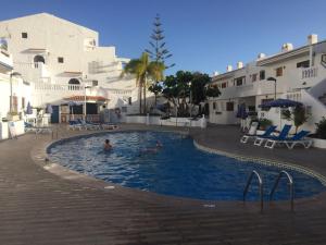 twee personen in een zwembad in een resort bij Los Cristianos Port Royale 184 in Los Cristianos