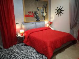a red bed with a red comforter in a bedroom at The Orange Groove in Bari