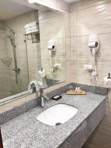 a bathroom with a sink and a mirror at Satama Hotel in Cap-Haïtien